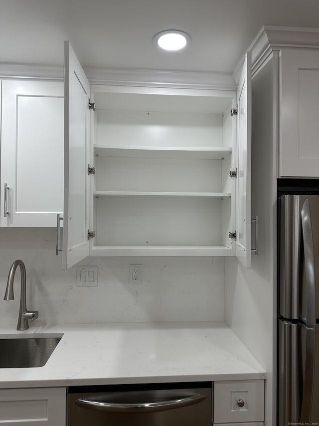 kitchen with a sink, appliances with stainless steel finishes, white cabinetry, and open shelves