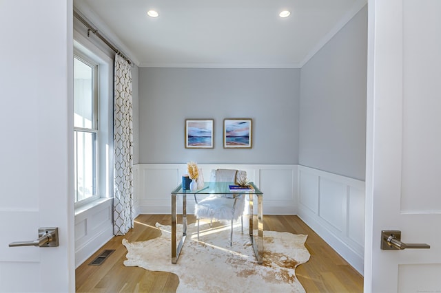 home office featuring crown molding, recessed lighting, visible vents, a decorative wall, and light wood-style flooring