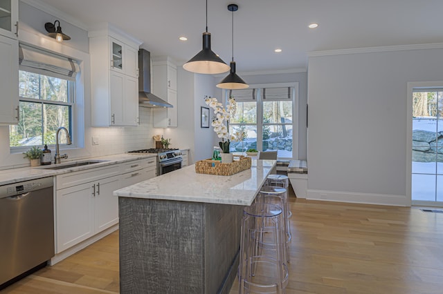 kitchen featuring appliances with stainless steel finishes, glass insert cabinets, white cabinets, a sink, and a kitchen island