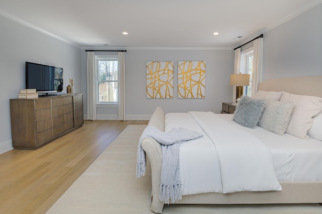 bedroom with ornamental molding, baseboards, and light wood finished floors