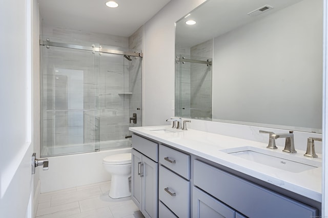 bathroom featuring enclosed tub / shower combo, toilet, a sink, and visible vents