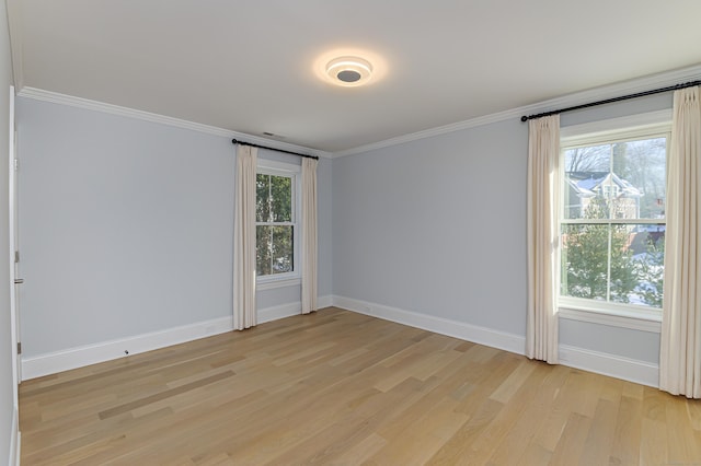 unfurnished room with light wood-type flooring, a wealth of natural light, and crown molding