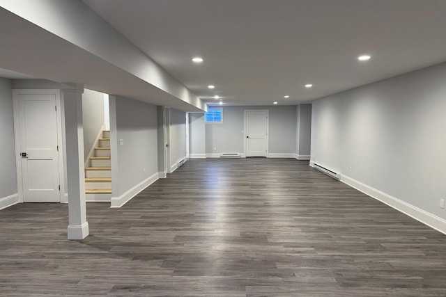 finished basement with a baseboard radiator, stairs, dark wood-type flooring, and recessed lighting