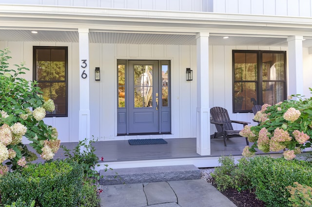 entrance to property with covered porch and board and batten siding