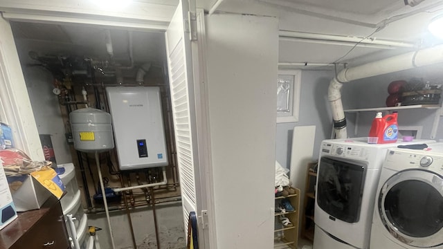 clothes washing area featuring water heater, laundry area, and separate washer and dryer