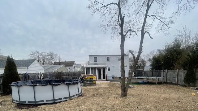 view of yard with a trampoline, a fenced in pool, and a fenced backyard