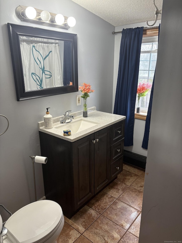 bathroom with toilet, a textured ceiling, and vanity