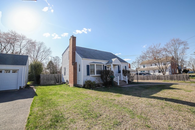 view of front facade featuring a chimney, fence, and a front lawn