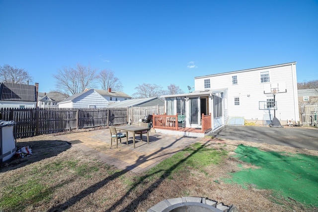 rear view of house with a fenced backyard and a patio