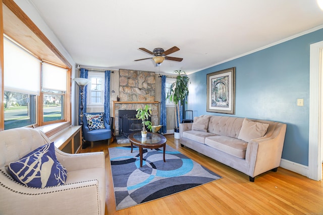 living room with ceiling fan, baseboards, crown molding, and wood finished floors