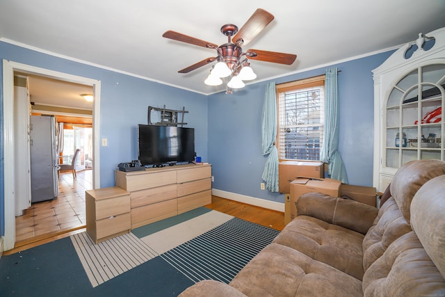 living room featuring baseboards, ornamental molding, a ceiling fan, and wood finished floors