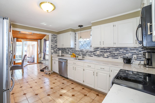 kitchen with stainless steel appliances, light countertops, a sink, and a healthy amount of sunlight