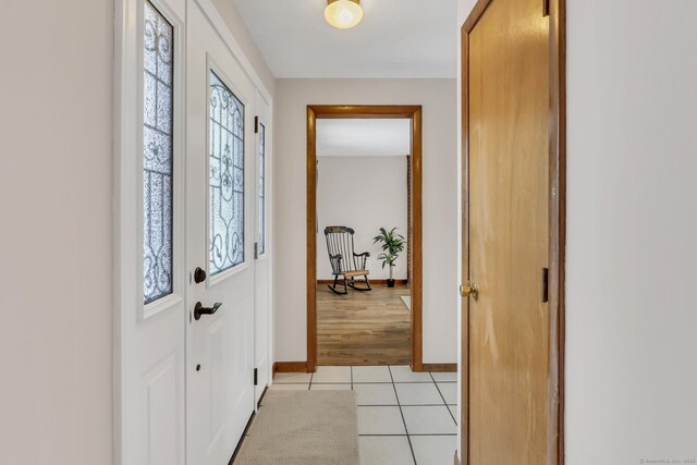 doorway to outside with light tile patterned floors and baseboards