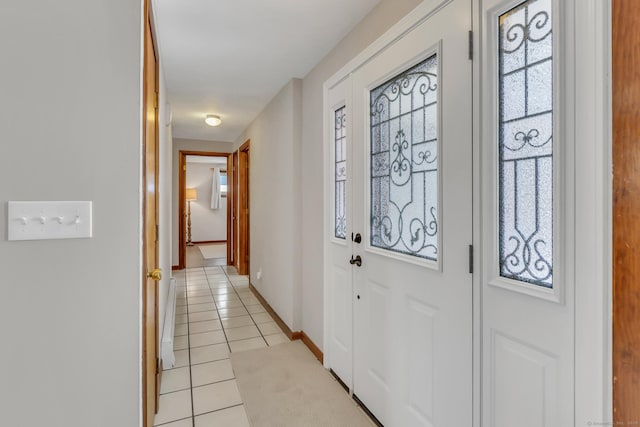 foyer entrance featuring plenty of natural light, baseboards, and light tile patterned floors