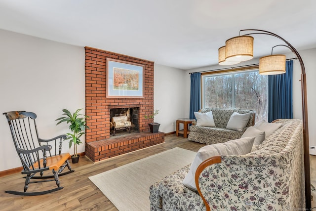 living area with light wood-type flooring, a brick fireplace, and baseboards