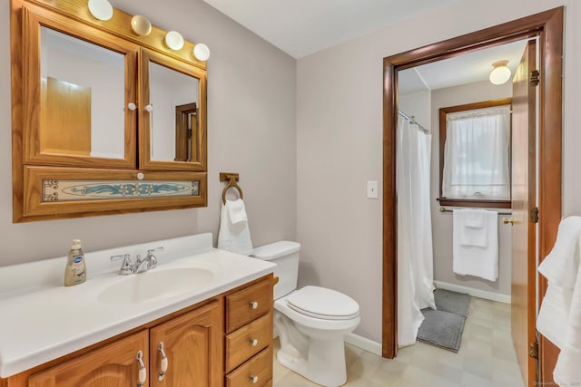 full bathroom with toilet, tile patterned floors, baseboards, and vanity