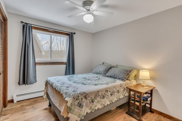 bedroom featuring light wood-type flooring, a baseboard radiator, ceiling fan, and baseboards