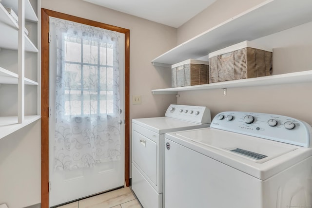 laundry area featuring light tile patterned floors, laundry area, and washer and clothes dryer