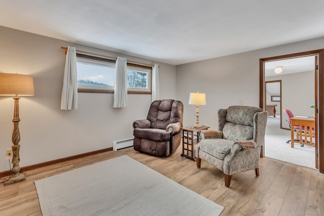 sitting room with a baseboard radiator, baseboards, and light wood-style flooring