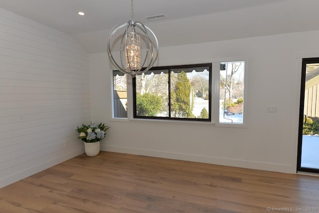 unfurnished dining area featuring lofted ceiling, recessed lighting, wood finished floors, and baseboards