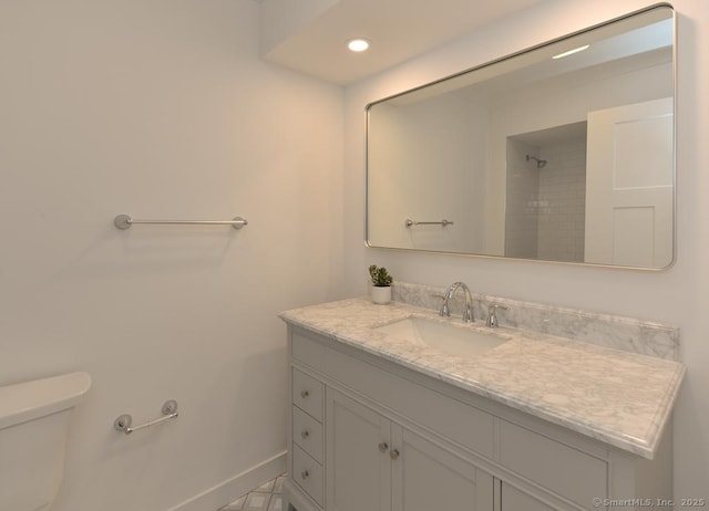 bathroom featuring toilet, recessed lighting, baseboards, and vanity