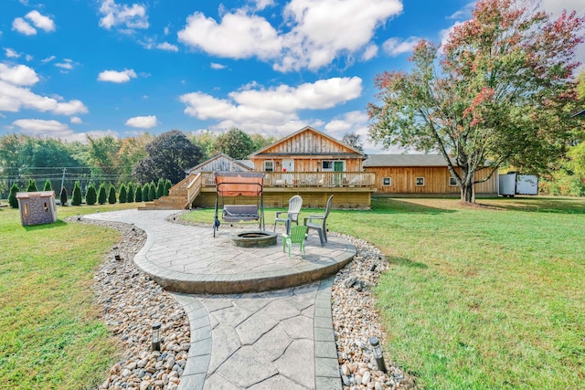 view of yard featuring a patio area, a fire pit, a wooden deck, and stairs