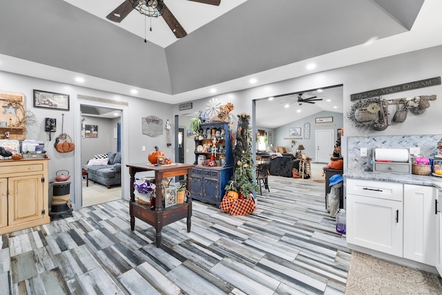 interior space featuring a tray ceiling, vaulted ceiling, recessed lighting, and ceiling fan