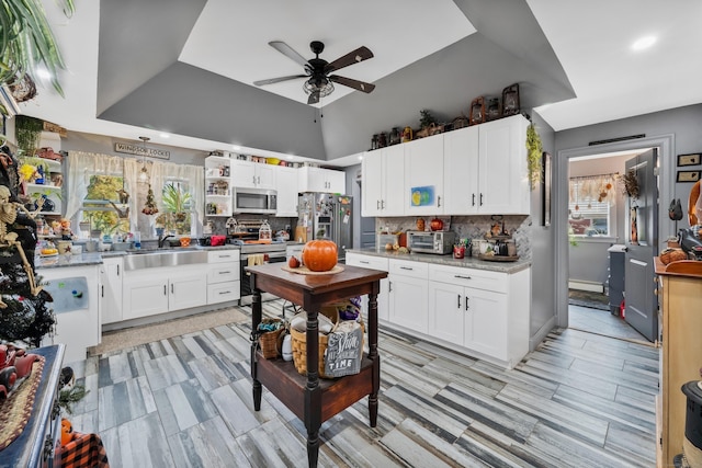 kitchen featuring appliances with stainless steel finishes, decorative backsplash, a sink, and white cabinets