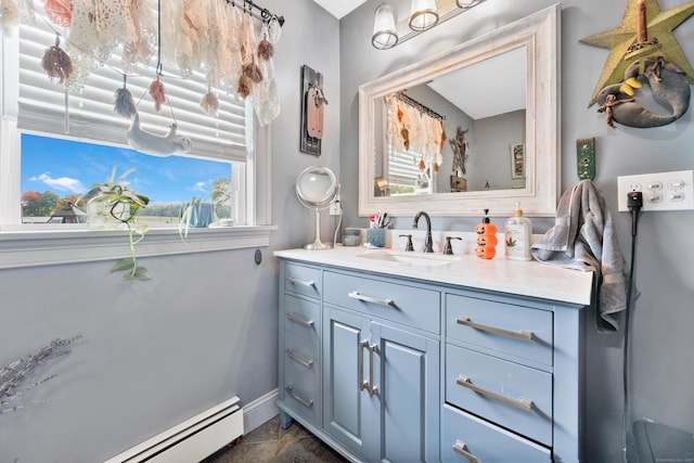 bathroom featuring baseboards, a baseboard heating unit, and vanity