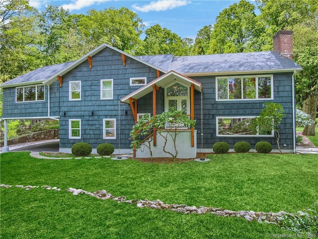 bi-level home with a chimney and a front yard