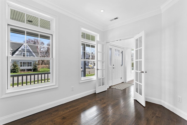 foyer with plenty of natural light, crown molding, baseboards, and wood finished floors