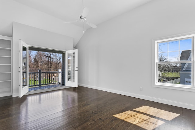 unfurnished room with healthy amount of natural light, lofted ceiling, wood finished floors, a ceiling fan, and baseboards