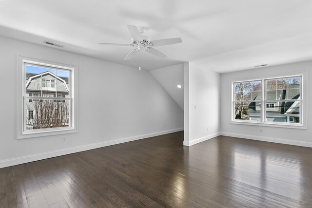 bonus room with plenty of natural light, dark wood finished floors, ceiling fan, and vaulted ceiling