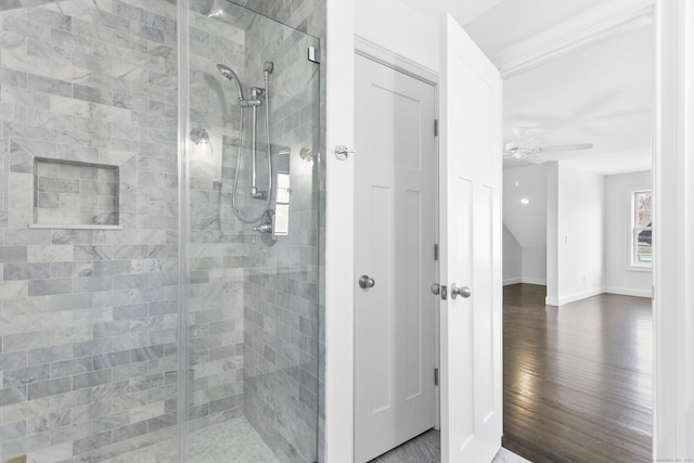 bathroom with a shower stall, wood finished floors, a ceiling fan, and baseboards