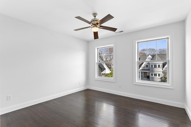 unfurnished room with a ceiling fan, baseboards, and dark wood finished floors