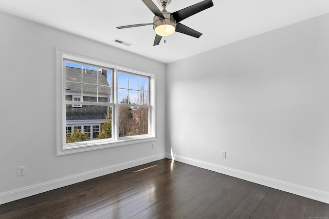 spare room with baseboards, dark wood-style flooring, and ceiling fan