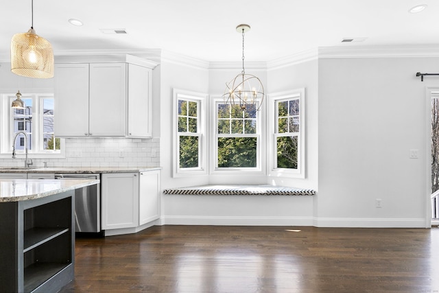 unfurnished dining area featuring a sink, a chandelier, dark wood-type flooring, crown molding, and baseboards