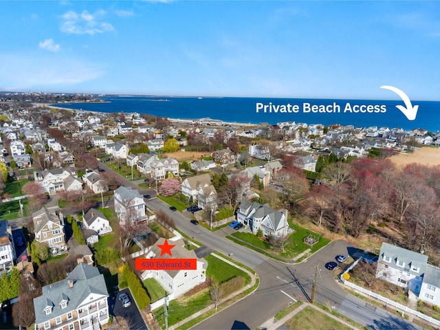 aerial view of property and surrounding area with nearby suburban area and a large body of water