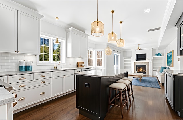 430 Edward St, Fairfield, CT 06824 - kitchen with crown molding, a ceiling fan, a kitchen island, open floor plan, and tasteful backsplash