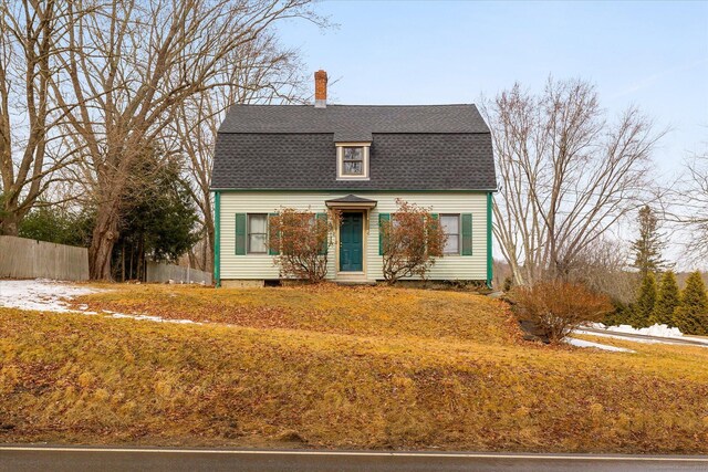 dutch colonial featuring fence, a gambrel roof, a shingled roof, and a chimney