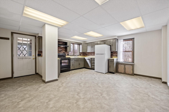 kitchen featuring black / electric stove, light countertops, stainless steel dishwasher, freestanding refrigerator, and range hood