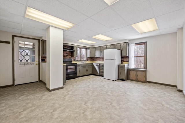 kitchen with freestanding refrigerator, stainless steel dishwasher, light countertops, black range with electric cooktop, and extractor fan