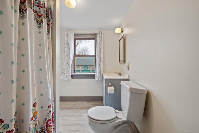 bathroom with vanity, wood finished floors, toilet, and baseboards