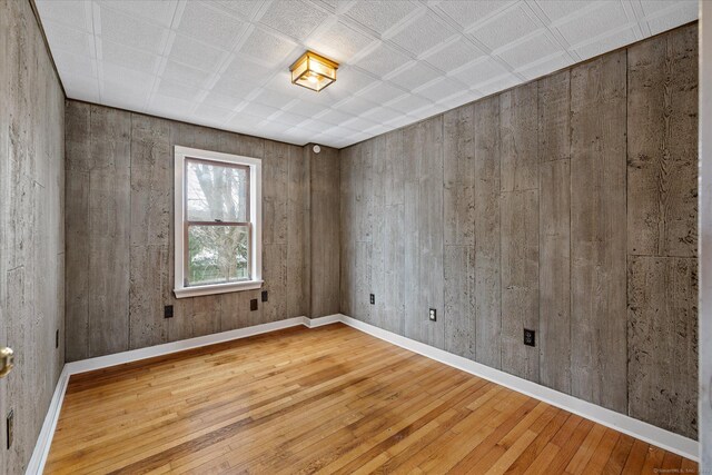 empty room with wood-type flooring and baseboards