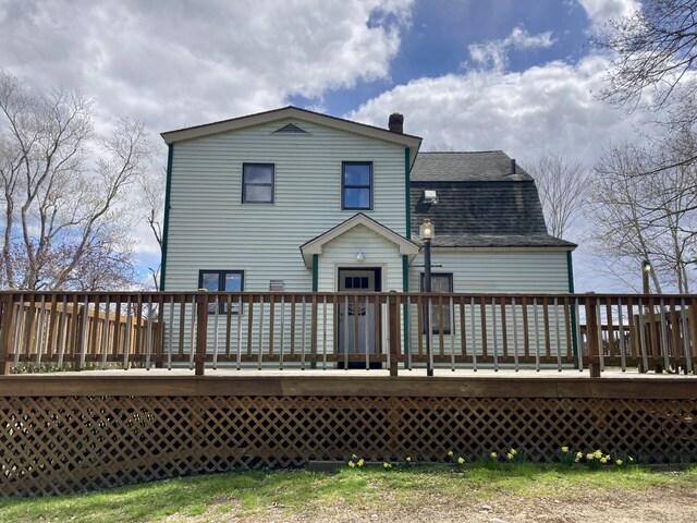 back of house featuring a deck and roof with shingles