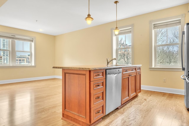 kitchen with a sink, baseboards, appliances with stainless steel finishes, light wood-type flooring, and brown cabinets