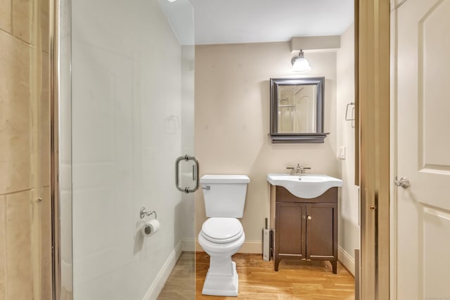 bathroom with toilet, baseboards, wood finished floors, and vanity