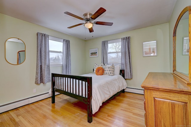 bedroom featuring a baseboard heating unit, ceiling fan, and light wood finished floors