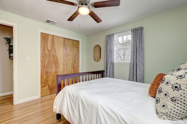 bedroom with a ceiling fan, baseboards, visible vents, light wood-style floors, and a closet