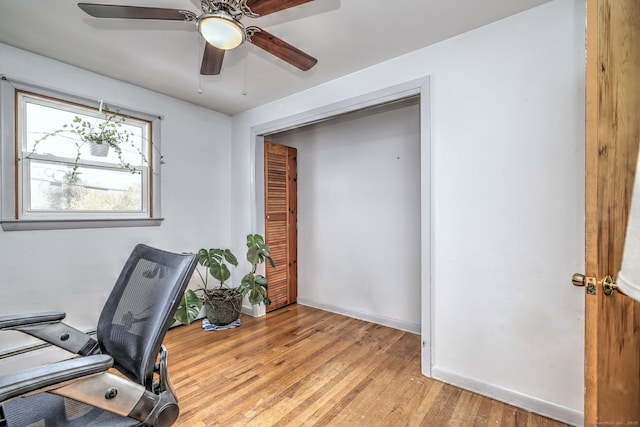 home office featuring light wood finished floors, ceiling fan, and baseboards